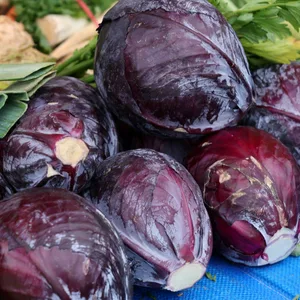 Obst und Gemüse liegt auf einem Verkaufsstand auf dem Wochenmarkt. Im Vordergrund liegt Rotkohl.