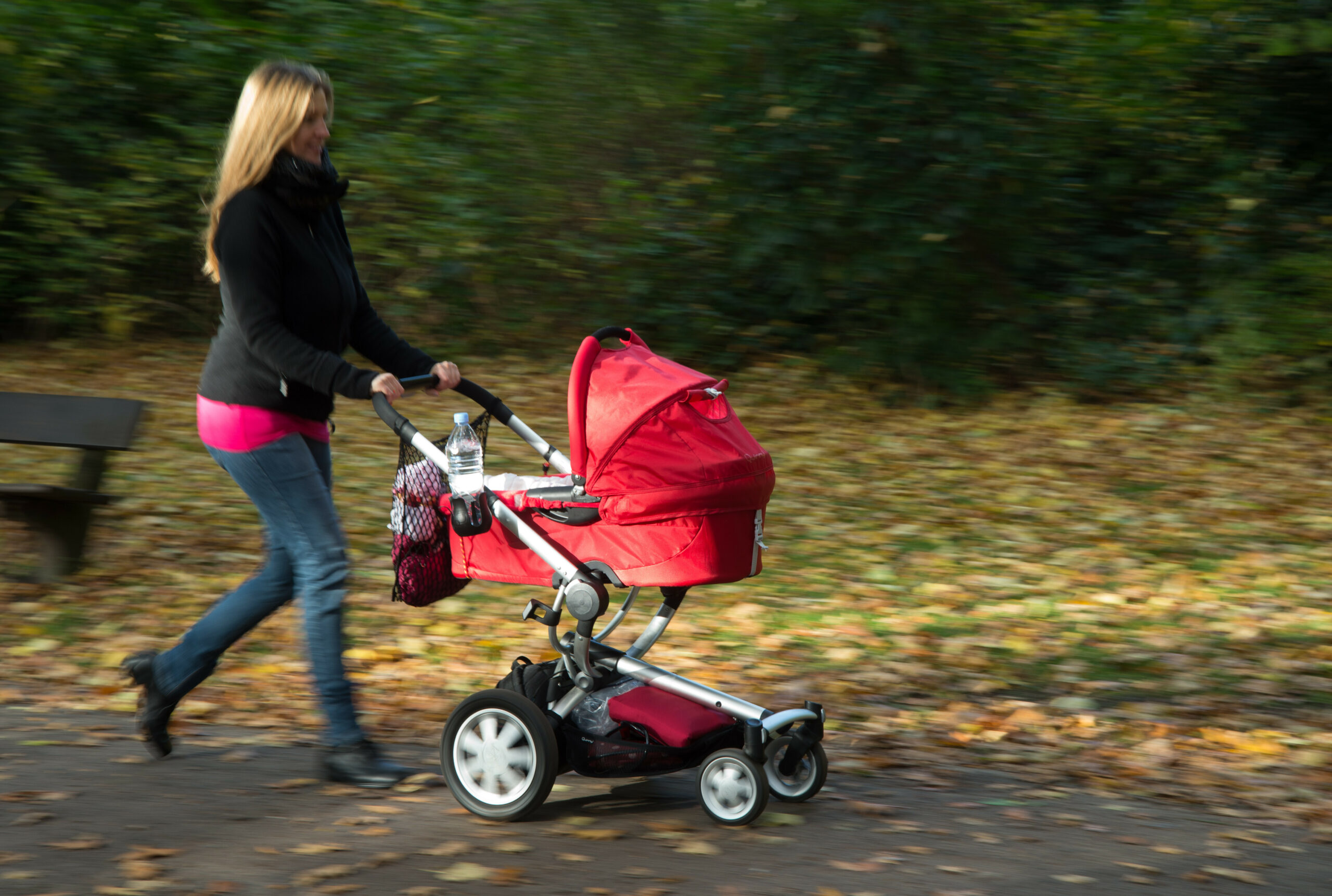 Eine Frau schiebt ihren Kinderwagen durch einen Park in Hamburg (Symbolbild).