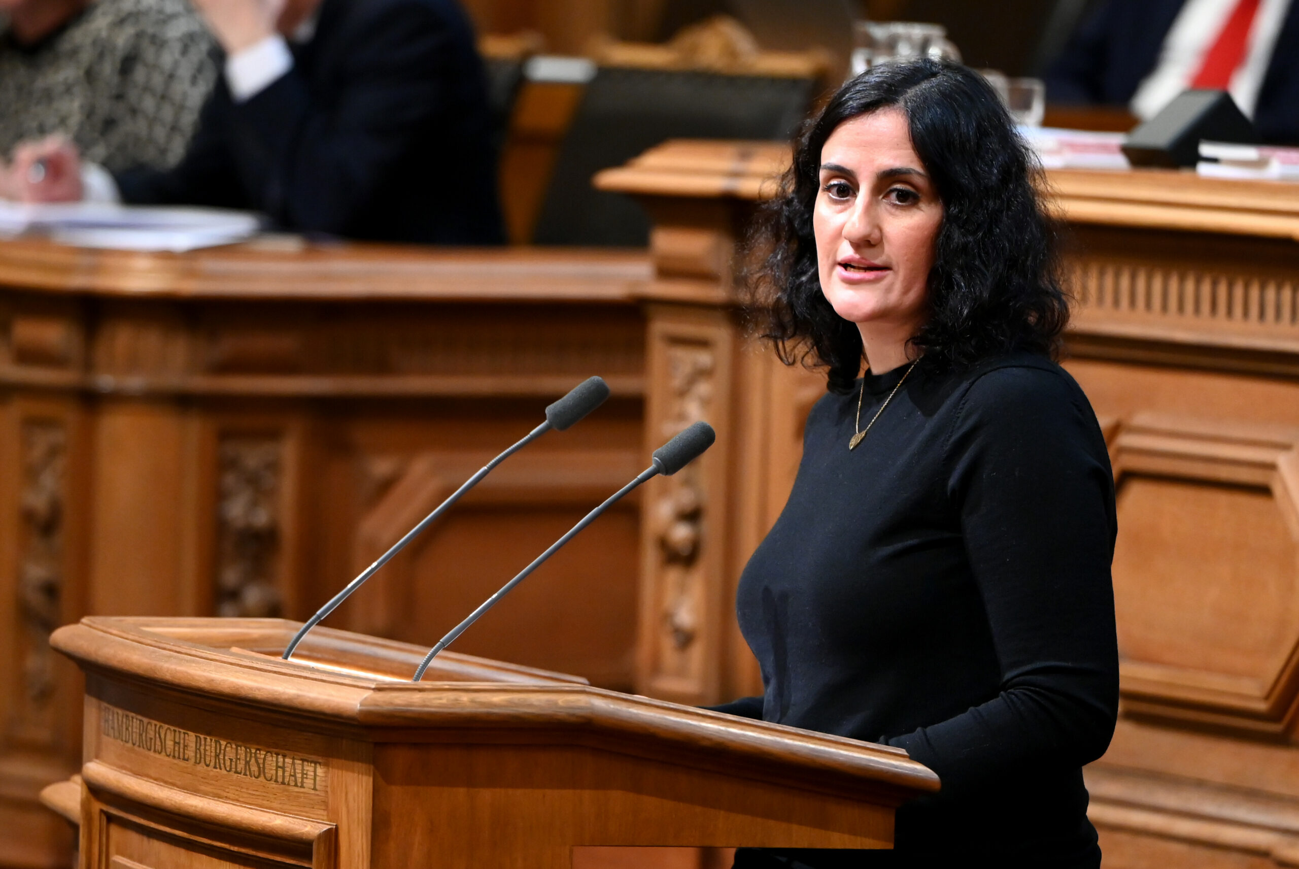 Dunkelhaarige Frau am Rednerpult