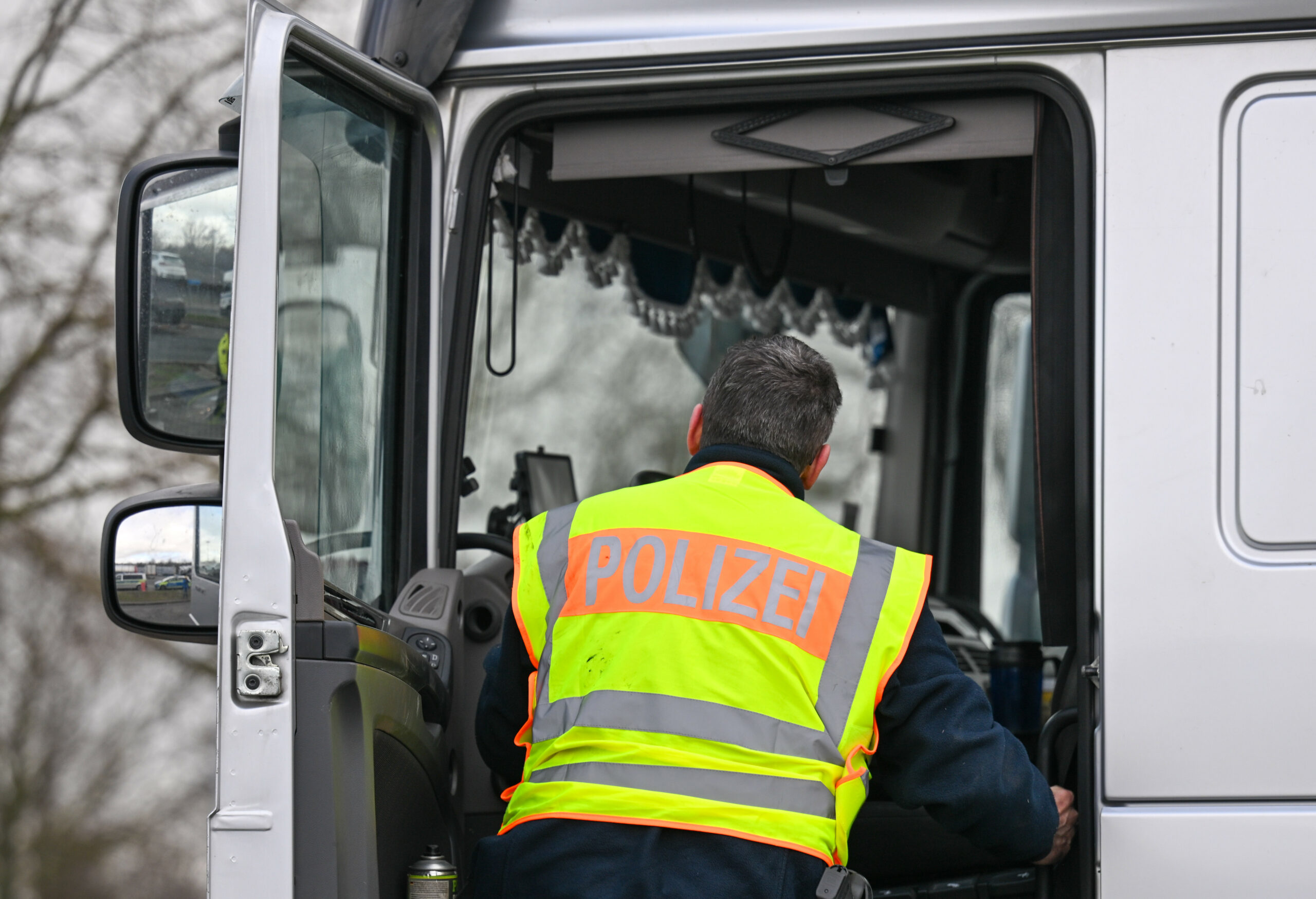 Ein Polizist kontrolliert einen Sattelzug (Symbolbild).