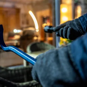 Ein Einbrecher späht eine Wohnung aus.