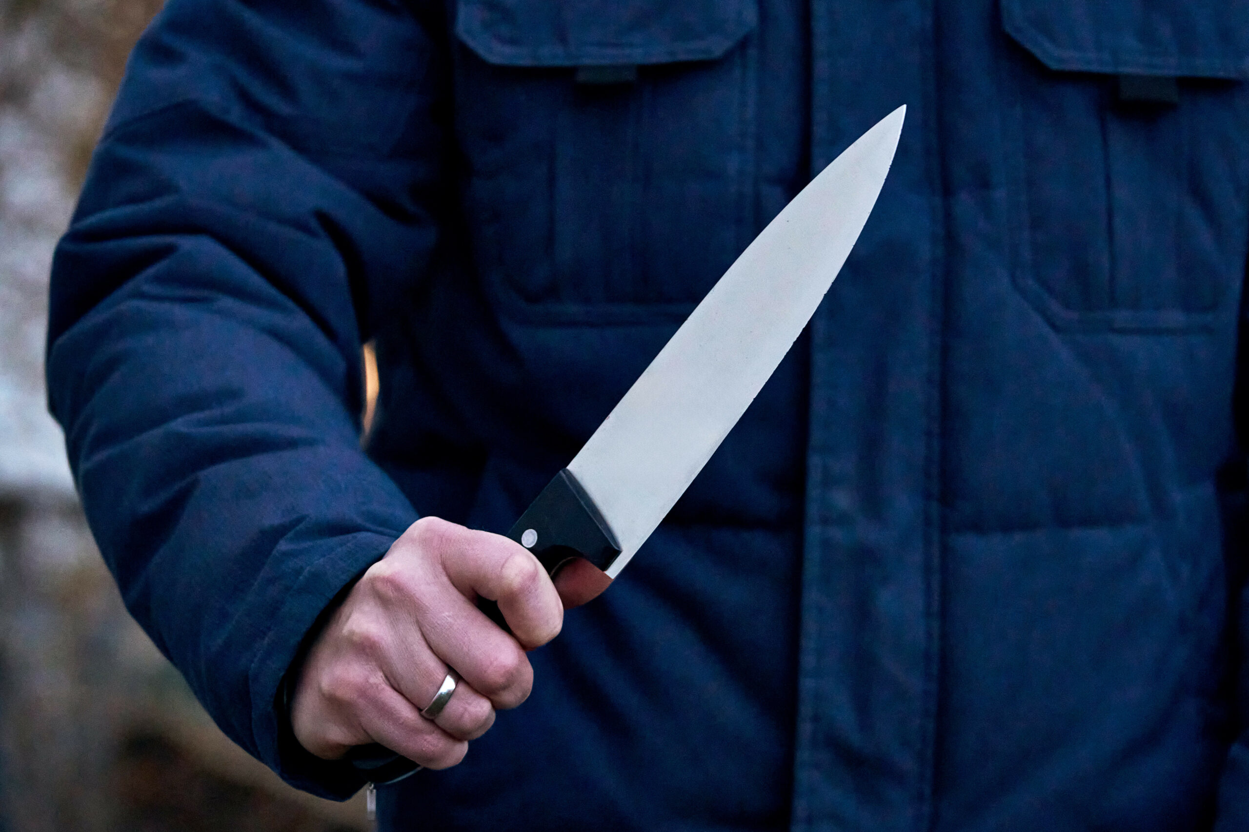 Ein bewaffneter Mann hält ein Messer bedrohlich in der Hand.