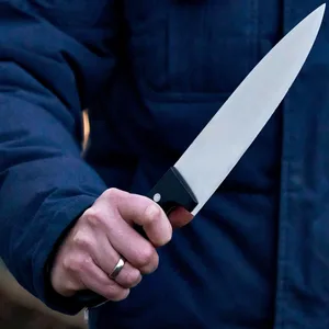 Ein bewaffneter Mann hält ein Messer bedrohlich in der Hand.