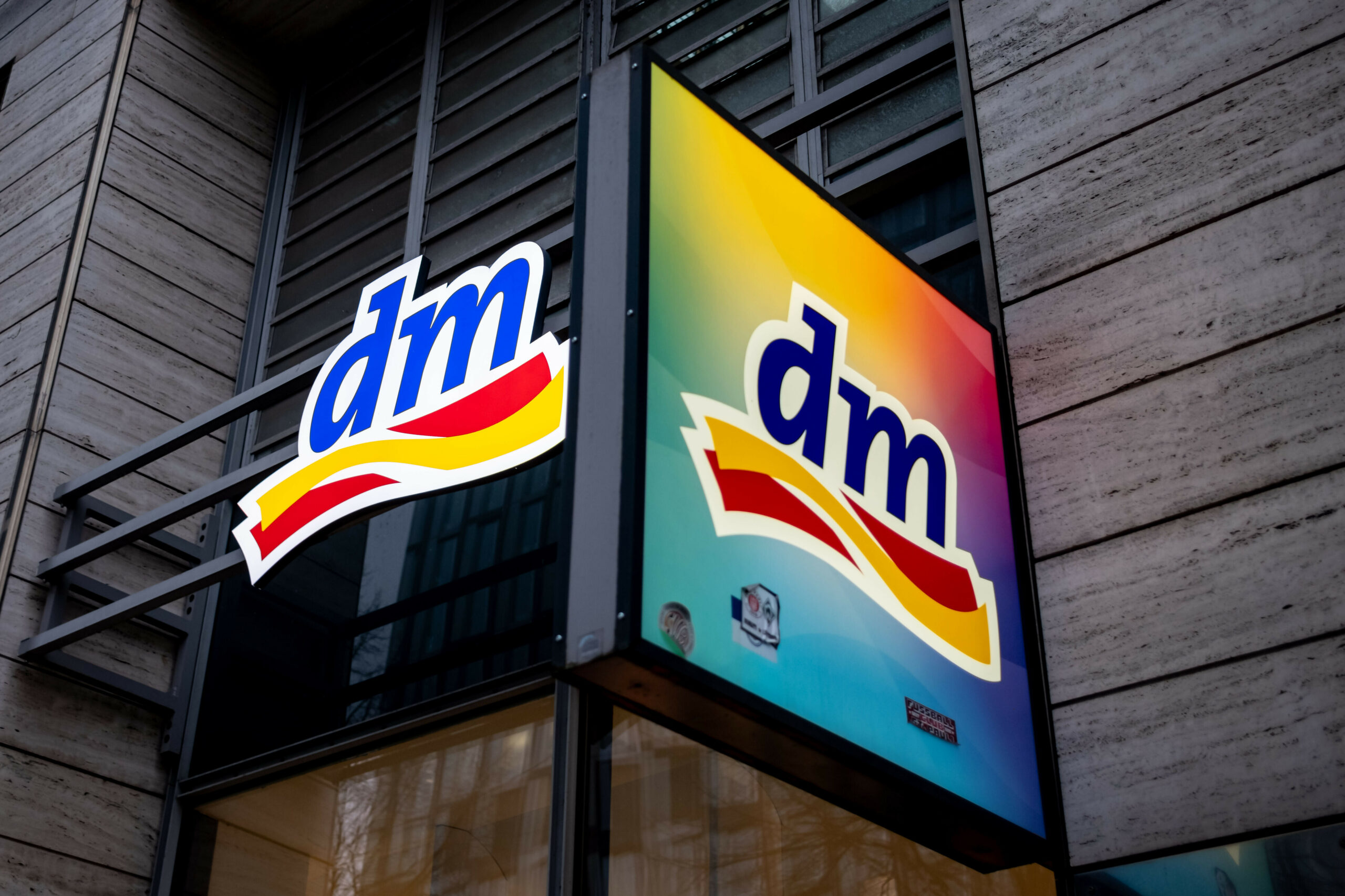 Das bunte Schild mit dem Schriftzug „dm“ hängt von außen an jeder Filiale der Drogerie.