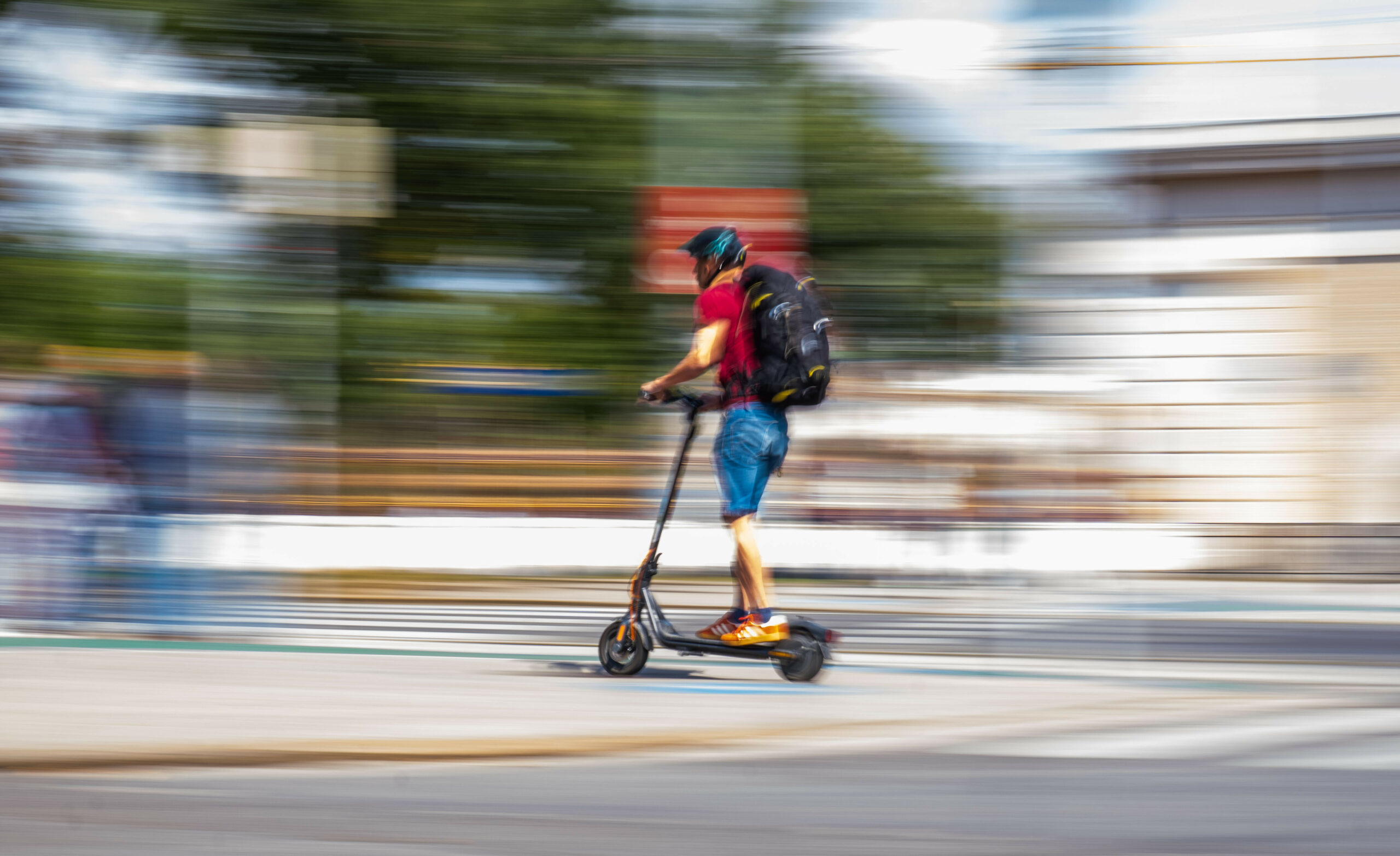 Ein Mann fährt auf einem E-Roller.