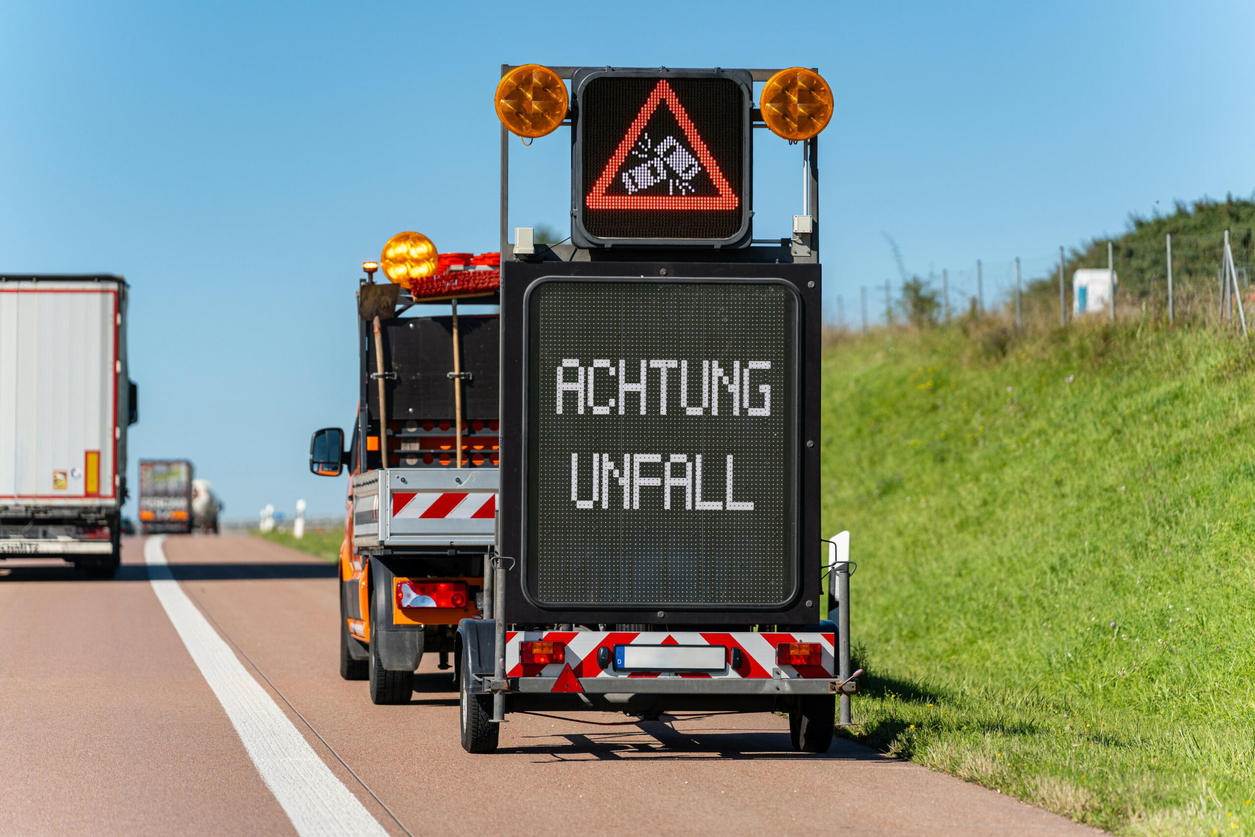 Ein elektronisches Verkehrsschild auf der Autobahn zeigt die Warnung „Achtung Unfall”.