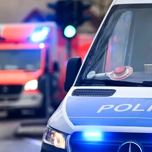 Ein Polizeiauto und ein Rettungswagen mit Blaulicht.