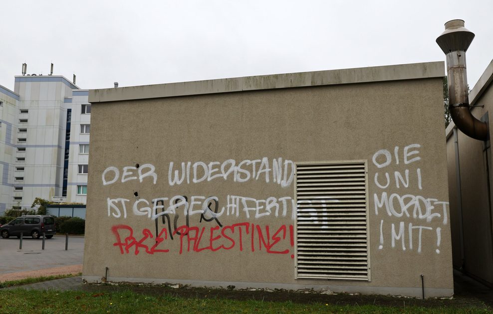 Die Schriftzüge „Der Widerstand ist gerechtfertigt“ und „Die Uni mordet mit!“ auf einer Gebäudefassade.