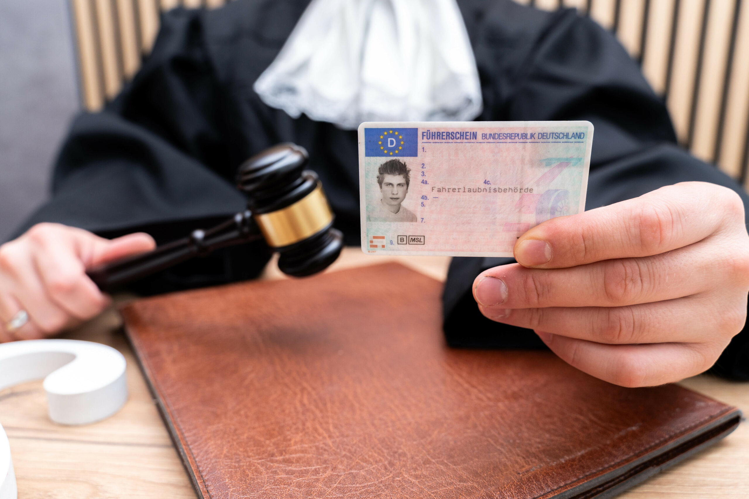 Ein Richter hält einen deutschen Führerschein der BRD in der Hand.