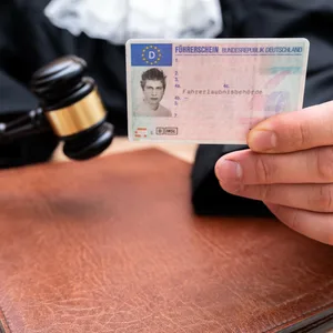 Ein Richter hält einen deutschen Führerschein der BRD in der Hand.