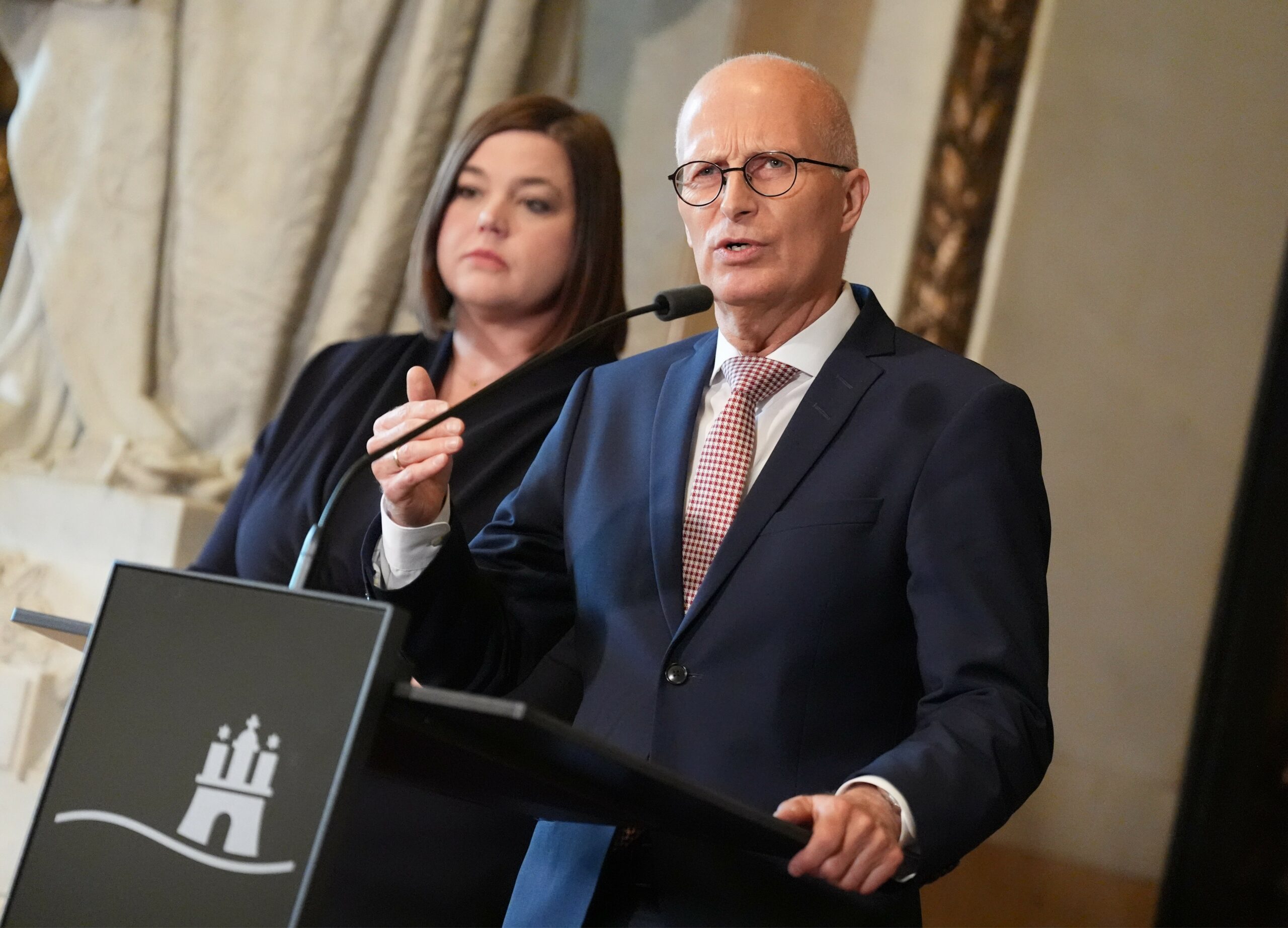 Peter Tschentscher und Katharina Fegebank stehen im Rathaus hinter einem Rednerpult.