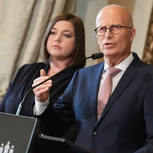 Peter Tschentscher und Katharina Fegebank stehen im Rathaus hinter einem Rednerpult.