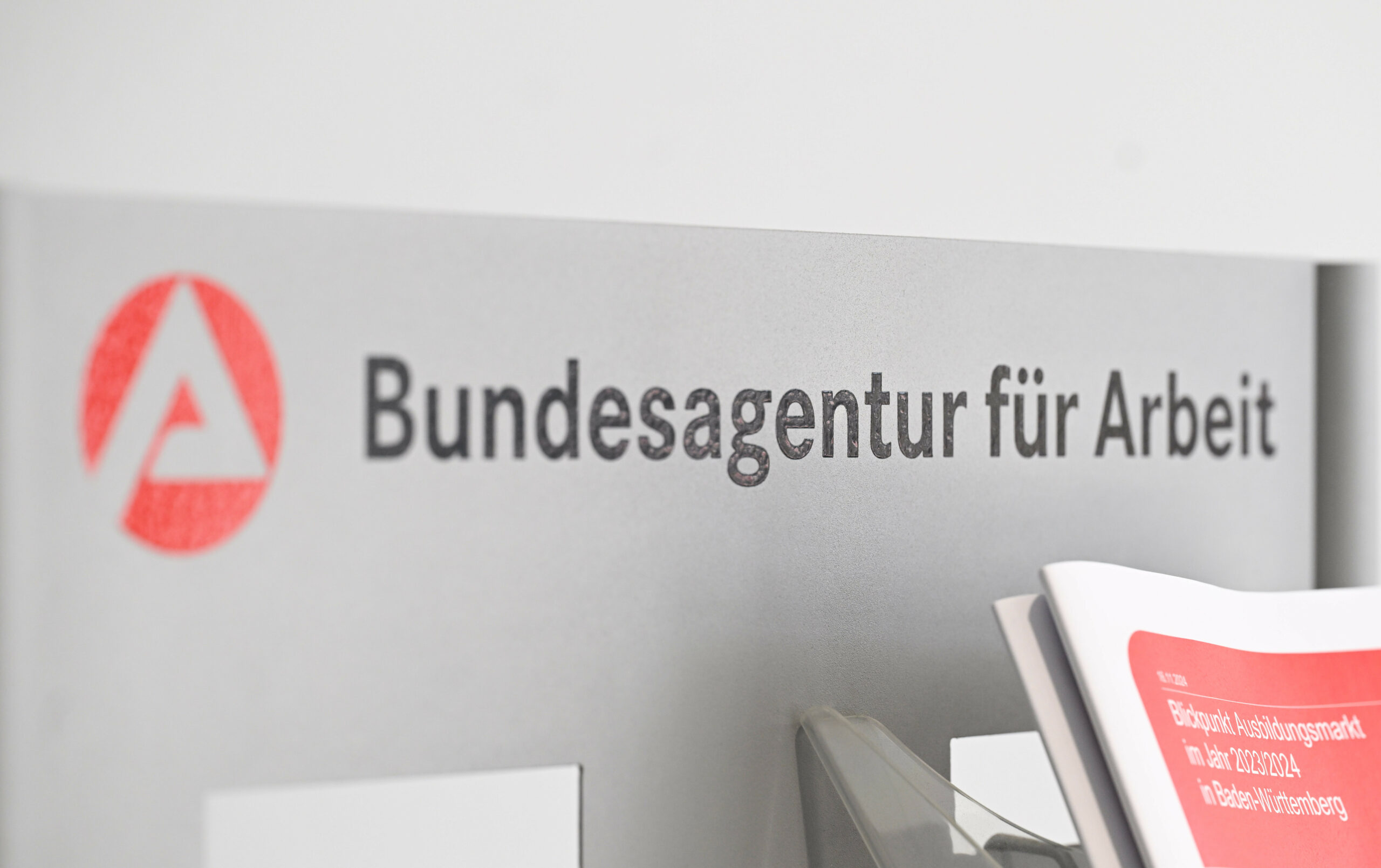 Ein Schild mit der Aufschrift "Bundesagentur für Arbeit" hängt am Eingang der Regionaldirektion in Stuttgart.