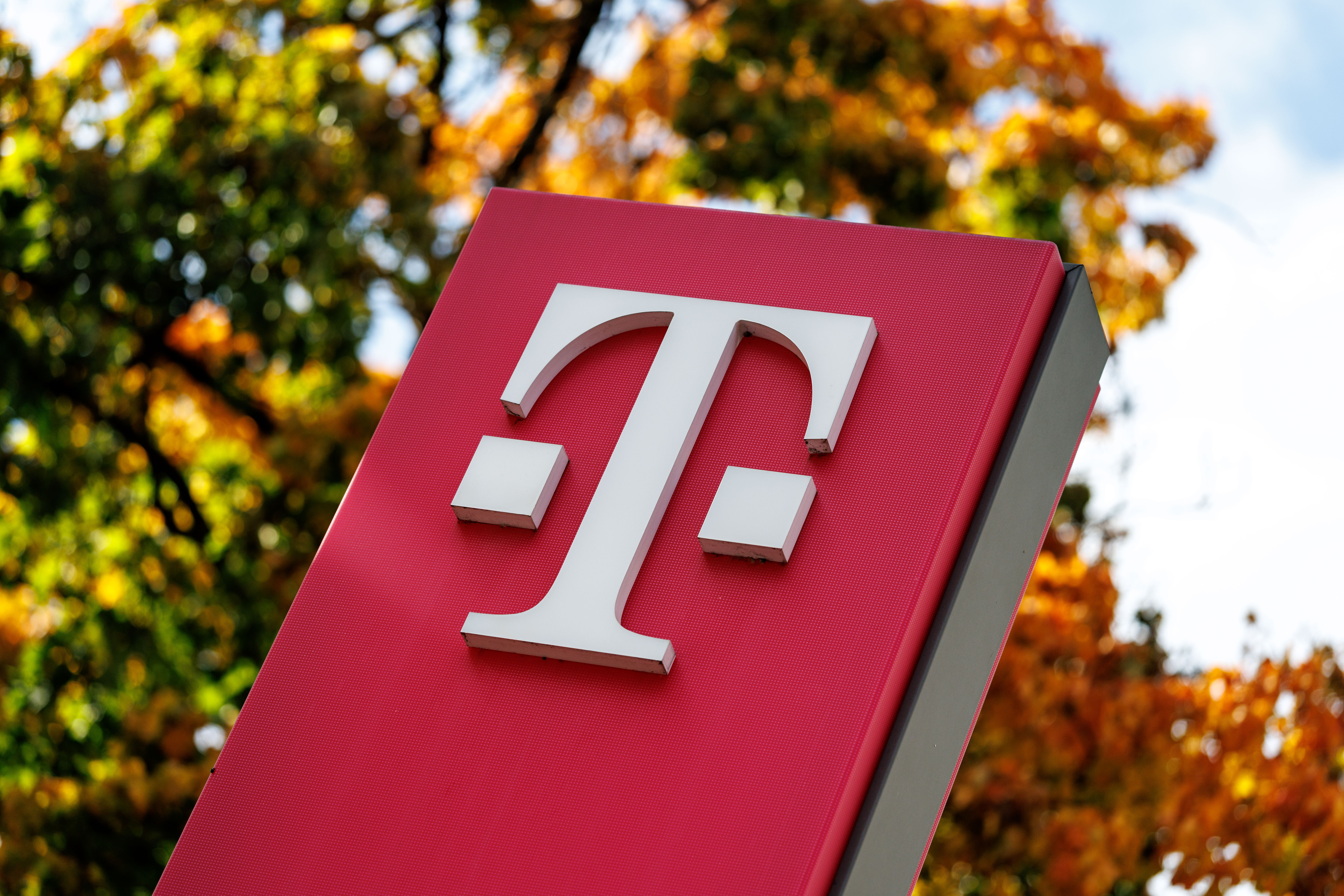 Das Logo vom Mobilfunkanbieter Deutsche Telekom ist am 15.10.2025 an einer Stele vor einem Bürogebäude in München (Bayern) zu sehen.
