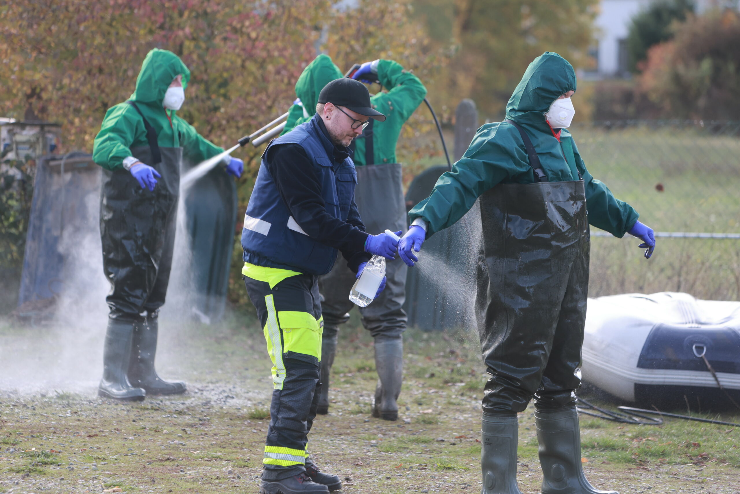 Feuerwehrleute werden nach dem Umgang mit Vogelgrippe-Kadavern desinfiziert.