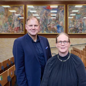 Hauke Heekeren, Präsident der Universität Hamburg und Antje Nagel, Sammlungsbeauftragte und Leitung Unimuseum, stehen vor drei Gemälden von Oskar Kokoschka, die jetzt an die Universität zurückgekehrt sind.