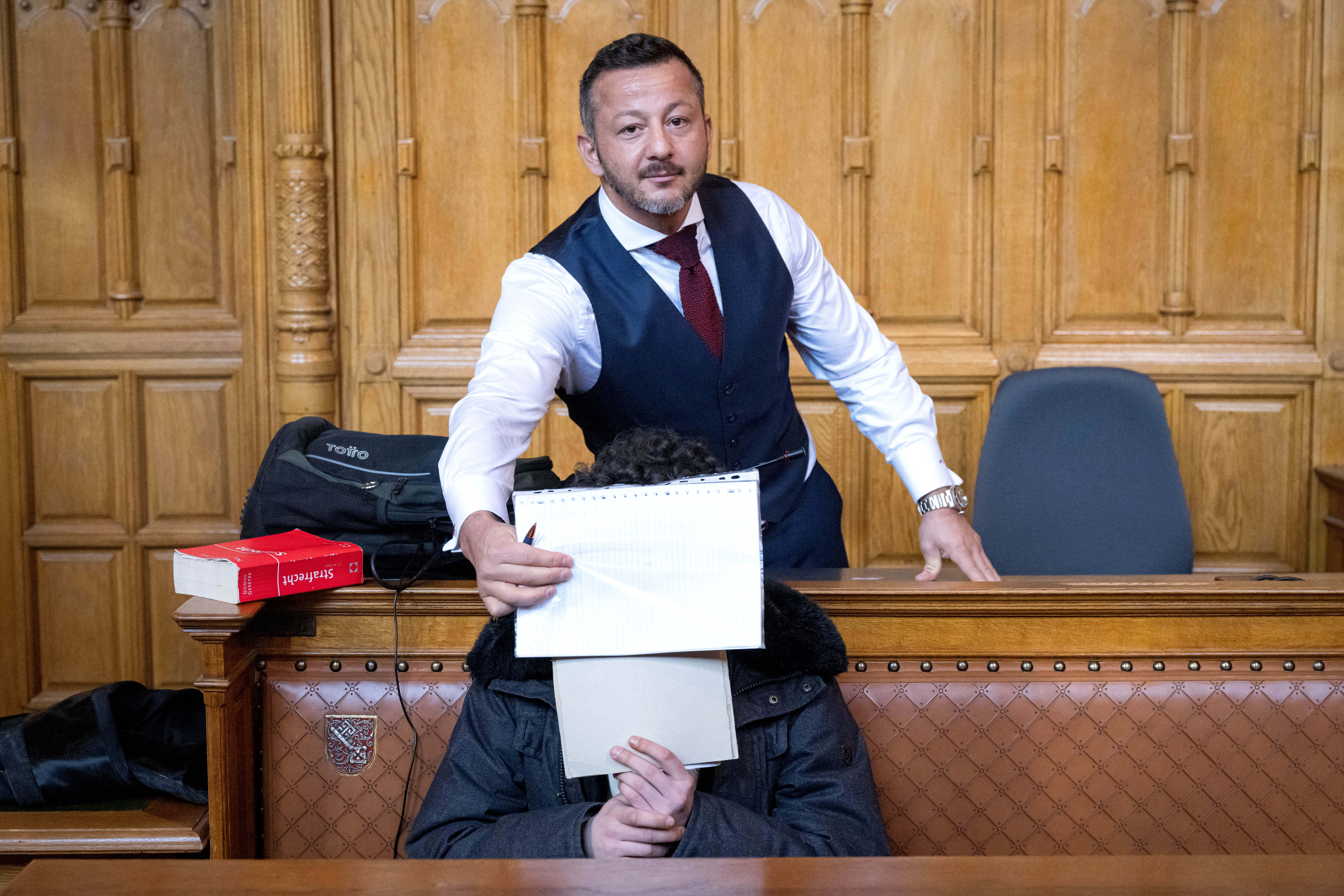 Der Angeklagte (vorn) im Prozess wegen Totschlags mit seinem Anwalt. Das Gericht bestätigt eine lange Haftstrafe, weil er einen auf dem Boden liegenden Menschen mit einem Sprung auf den Kopf getötet hat.