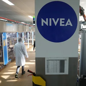 Eine Mitarbeiterin geht durch eine Produktionshalle der Nivea Creme in der Beiersdorf Manufacturing Hamburg.