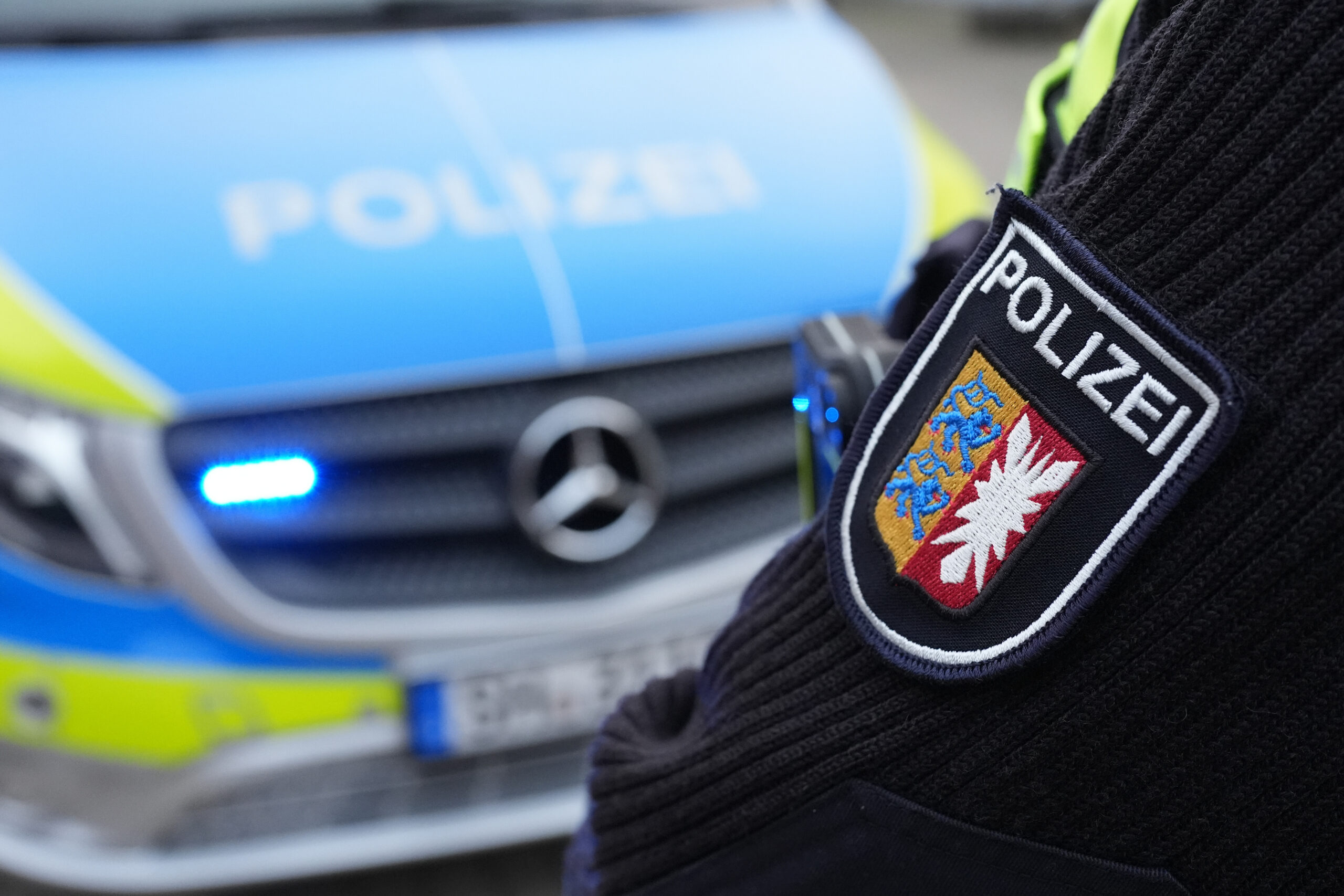 Das Landeswappen von Schleswig-Holstein und der Schriftzug „Polizei“ sind auf dem Ärmel einer Polizistin zu sehen.