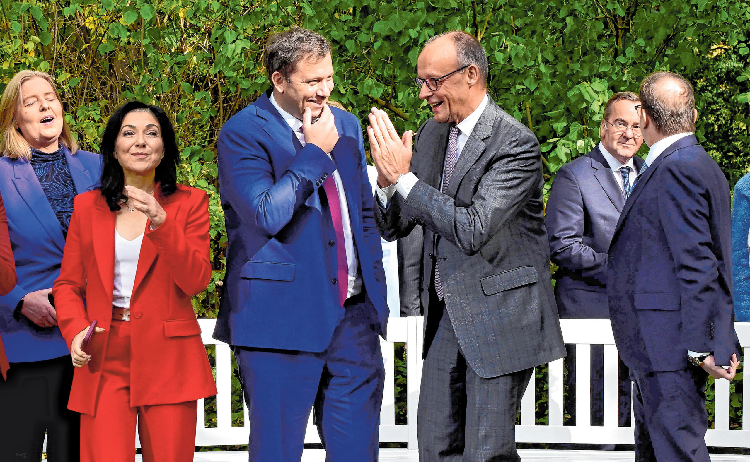Friedrich Merz (CDU) und Lars Klingbeil (SPD) unterhalten sich, umgeben von anderen Mitgliedern der Bundesregierung.
