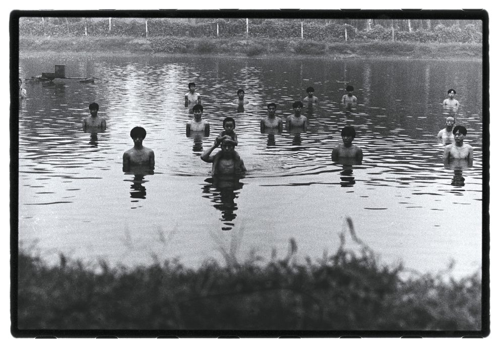 Fotografie einer Künstlergruppe beim Baden in einem Fluss