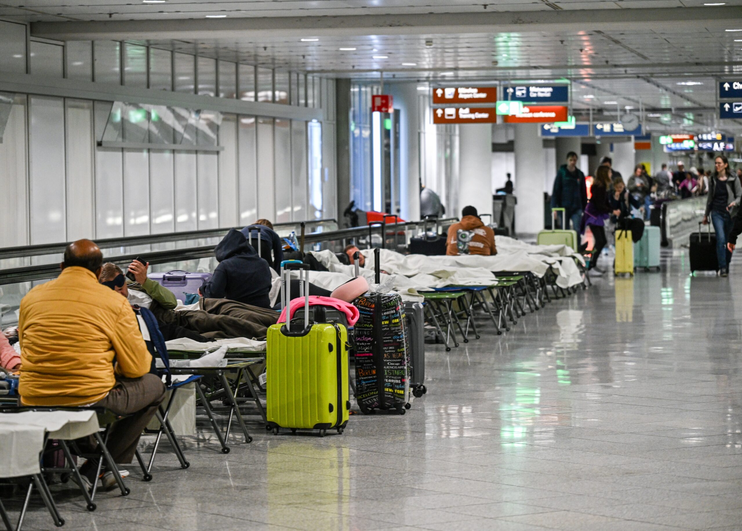 Passagiere warten nach Drohnensichtungen und Flugausfällen in Flughafen München auf Feldbetten.