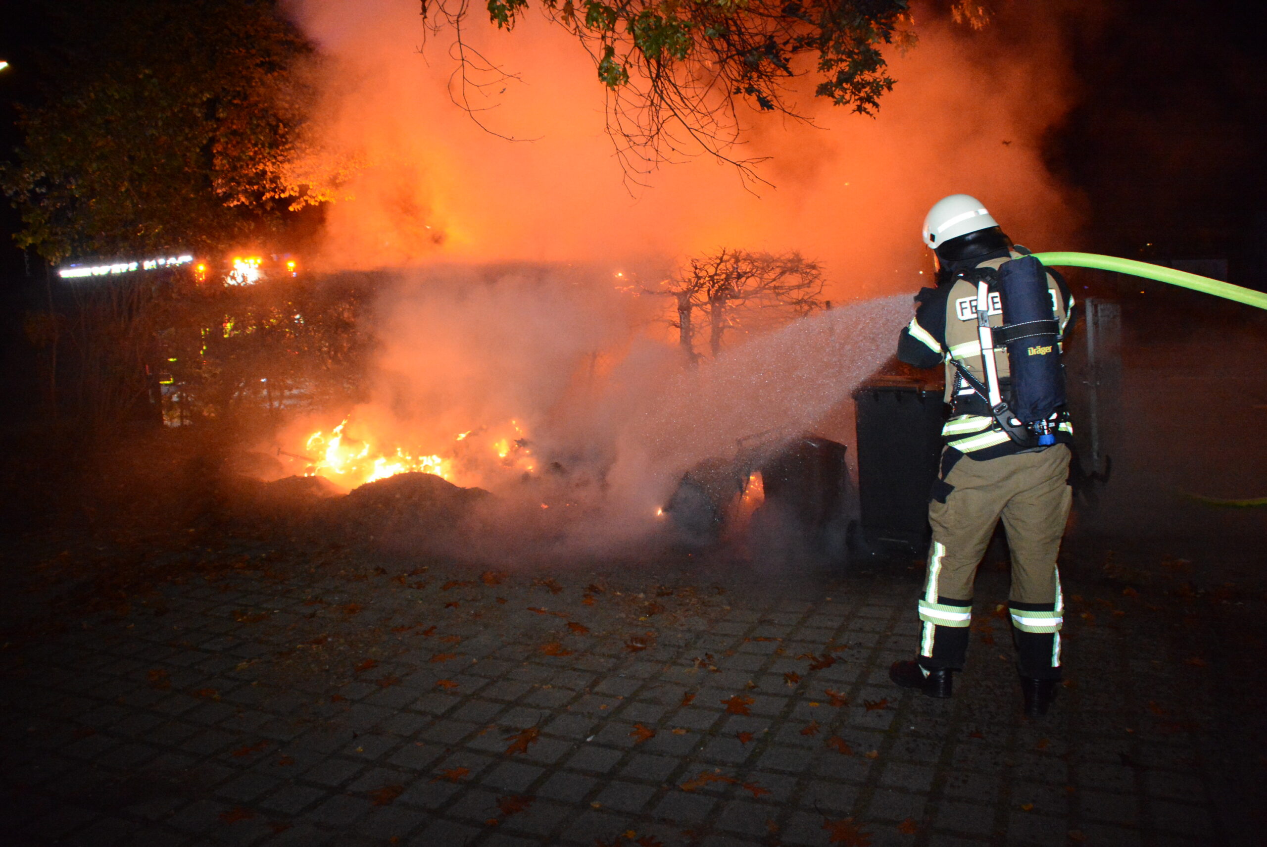 Ein Feuerwehrmann löscht die Flammen am Südring in Wentorf.