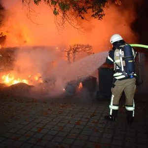 Ein Feuerwehrmann löscht die Flammen am Südring in Wentorf.