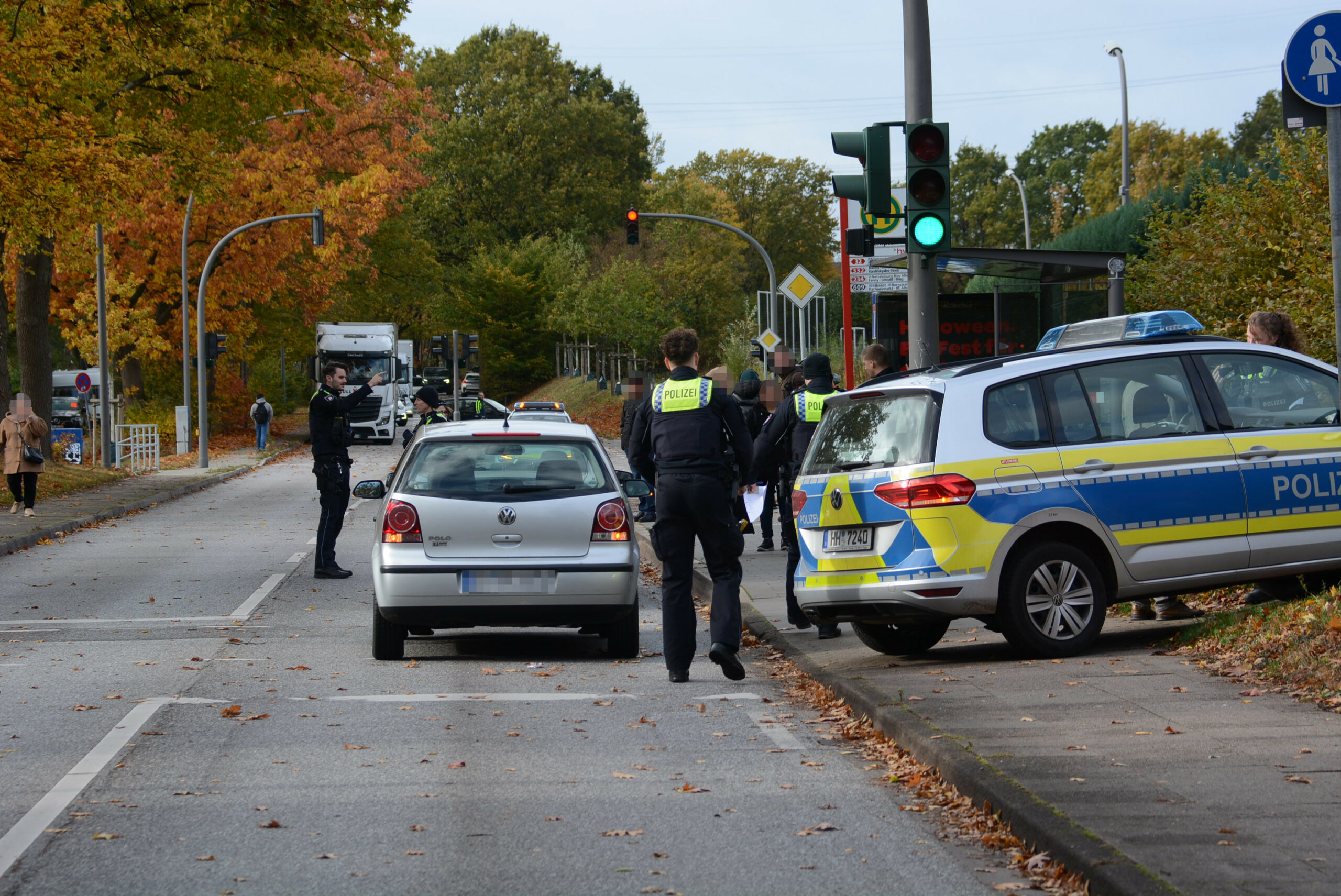 Polizisten stehen am Unfallort an einer Bushaltestelle.
