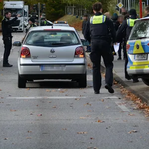Polizisten stehen am Unfallort an einer Bushaltestelle.