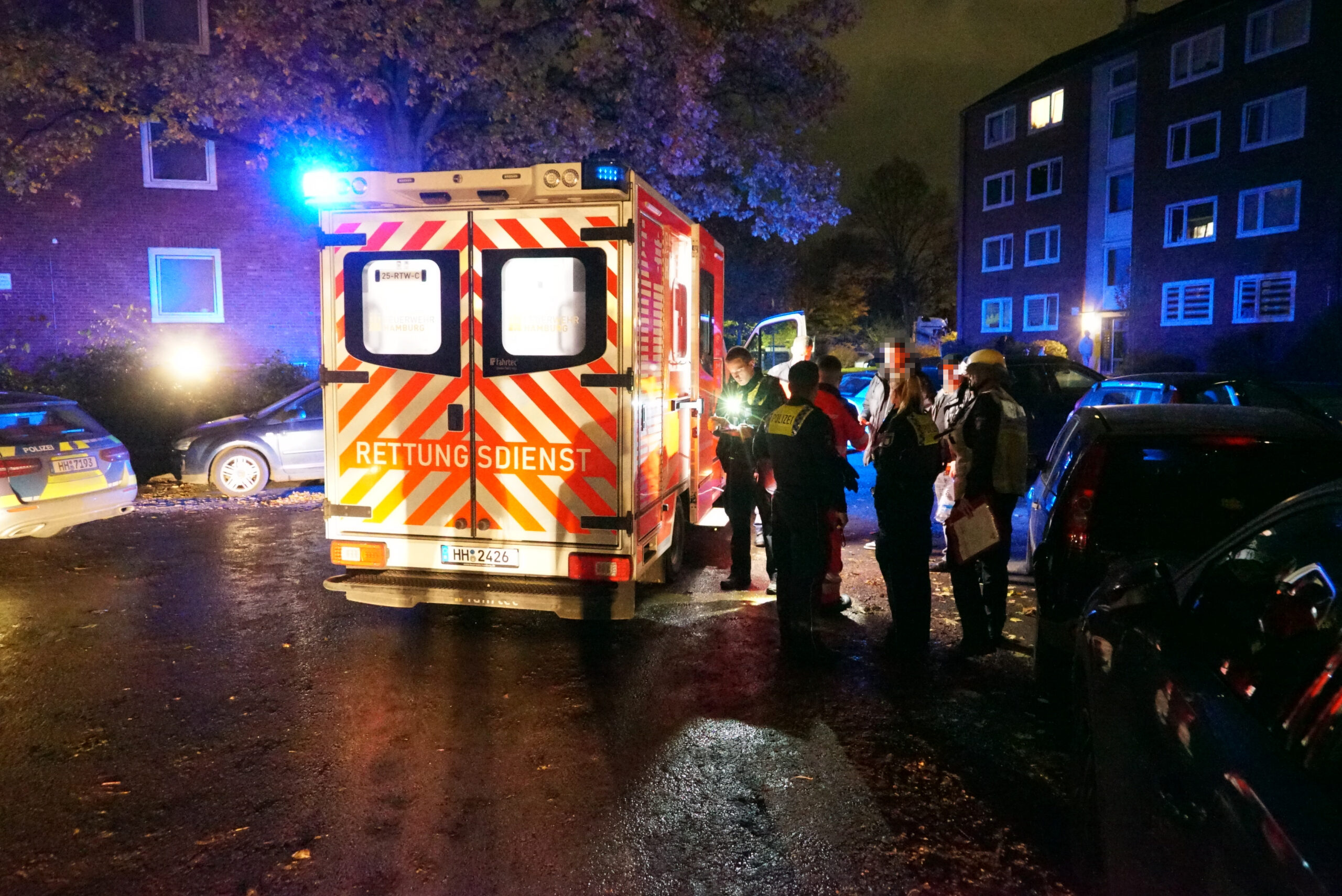 Ein Rettungswagen steht vor einem Mehrfamilienhaus.