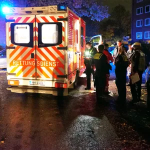 Ein Rettungswagen steht vor einem Mehrfamilienhaus.