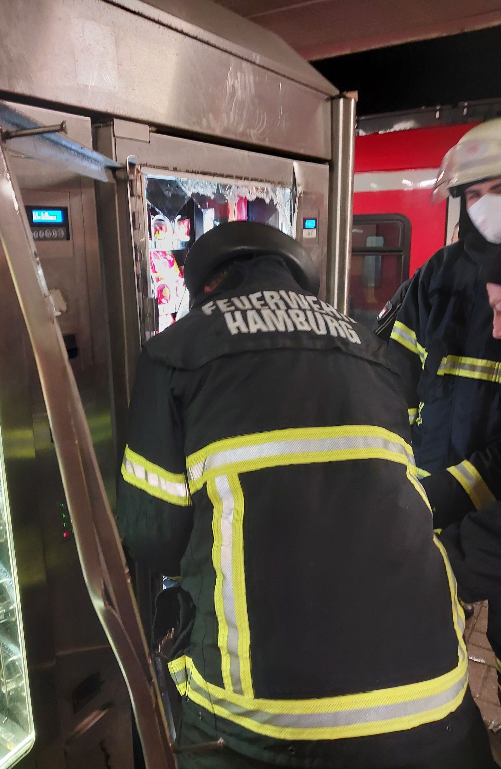 Feuerwehrkräfte öffnen einen Snackautomaten.