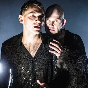 Zwei Schauspieler in dunklen Kostümen