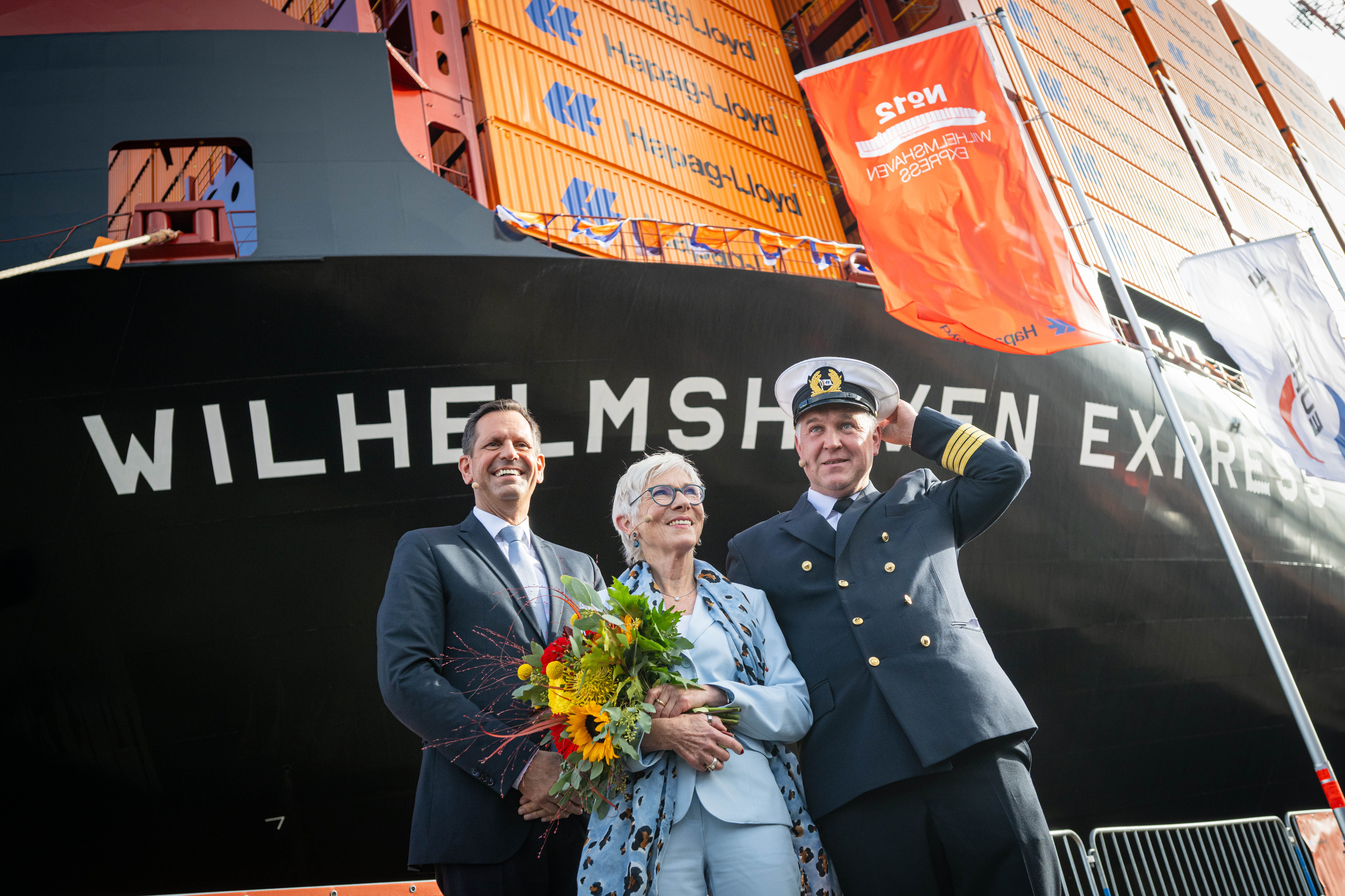 Olaf Lies (SPD, l-r), Ministerpräsident von Niedersachsen, Wibke Friedrichs-Firmin, Taufpatin und Tomasz Michalski, Kapitän, stehen nach der Taufe vor dem Containerschiff „Wilhelmshaven Express“.