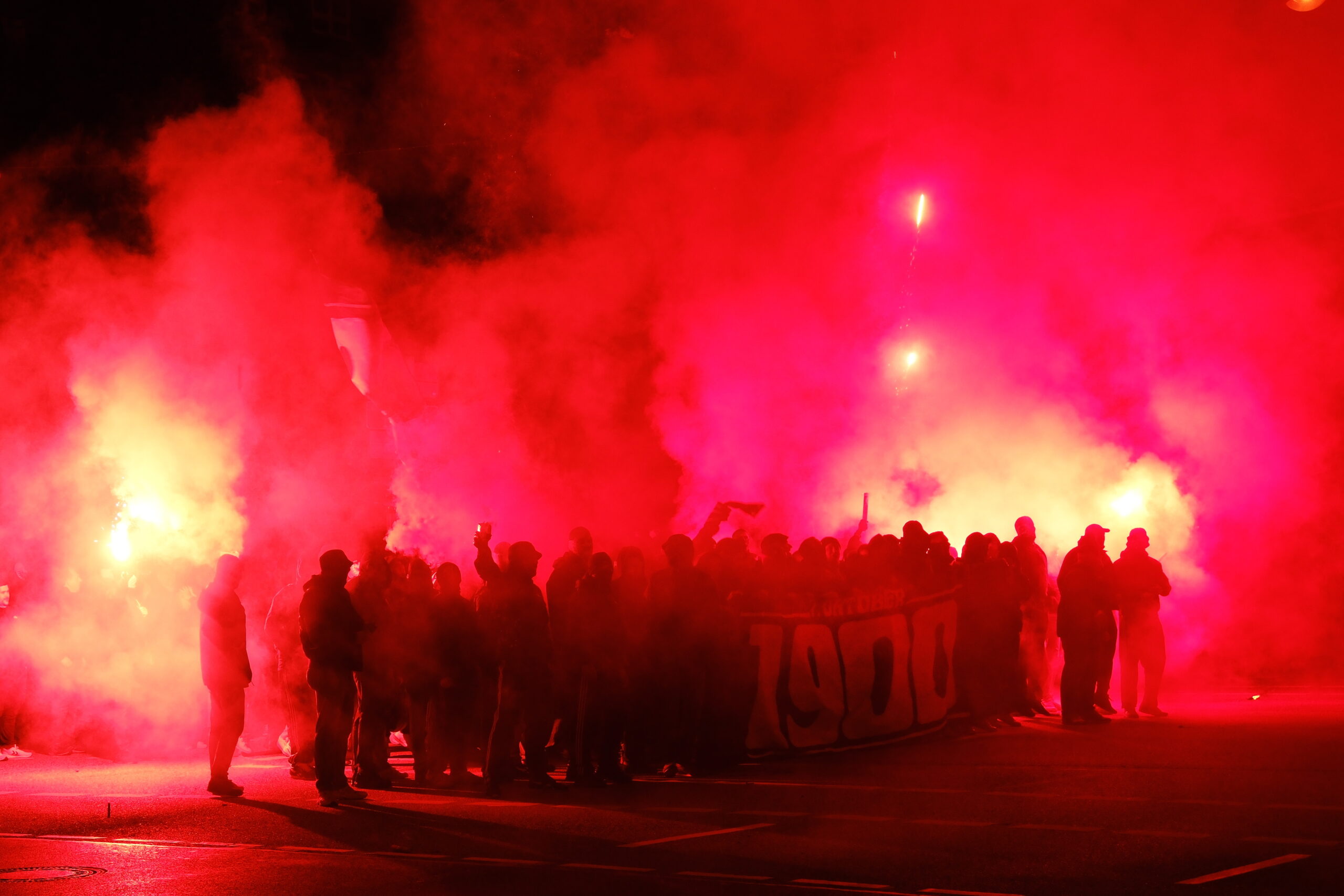 Mit Böllern und Pyrotechnik ziehen rund 250 Holstein-Kiel-Fans in der Nacht durch die Innenstadt.