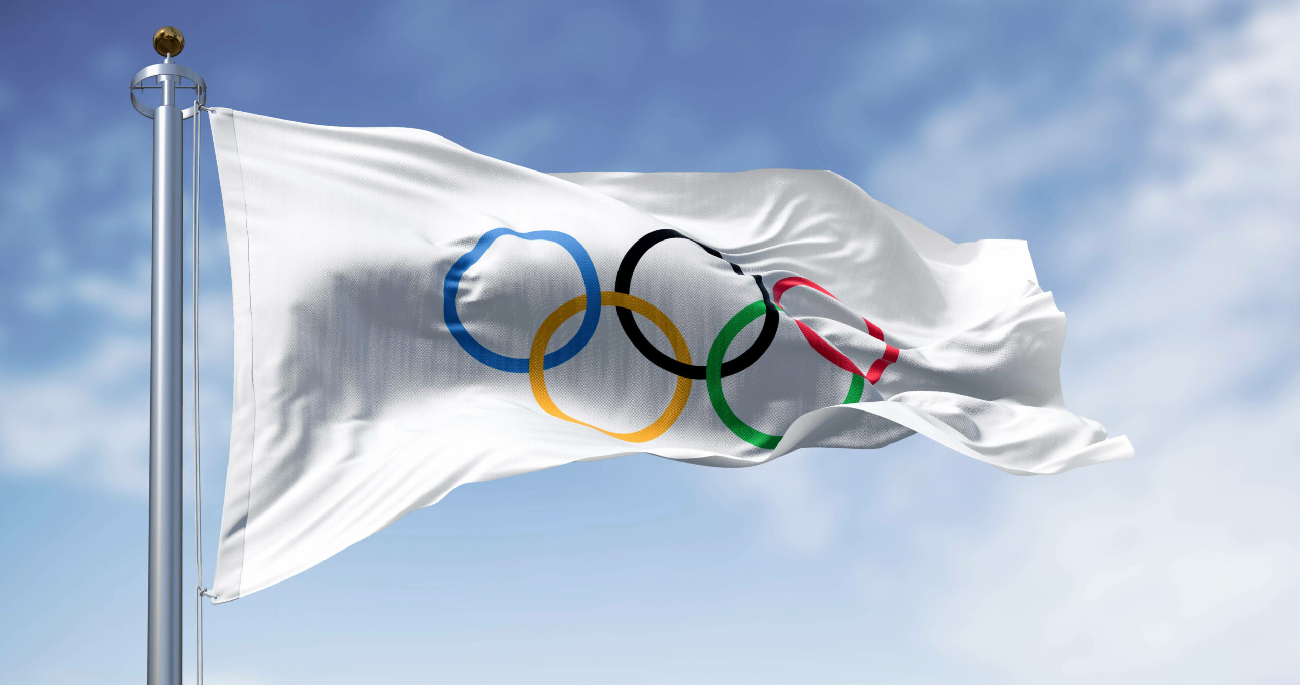 Weiße Flagge mit den olympischen Ringen weht im Wind.