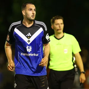 Levin Öztunali auf dem Platz im HSV-Trikot neben einem Schiedsrichter