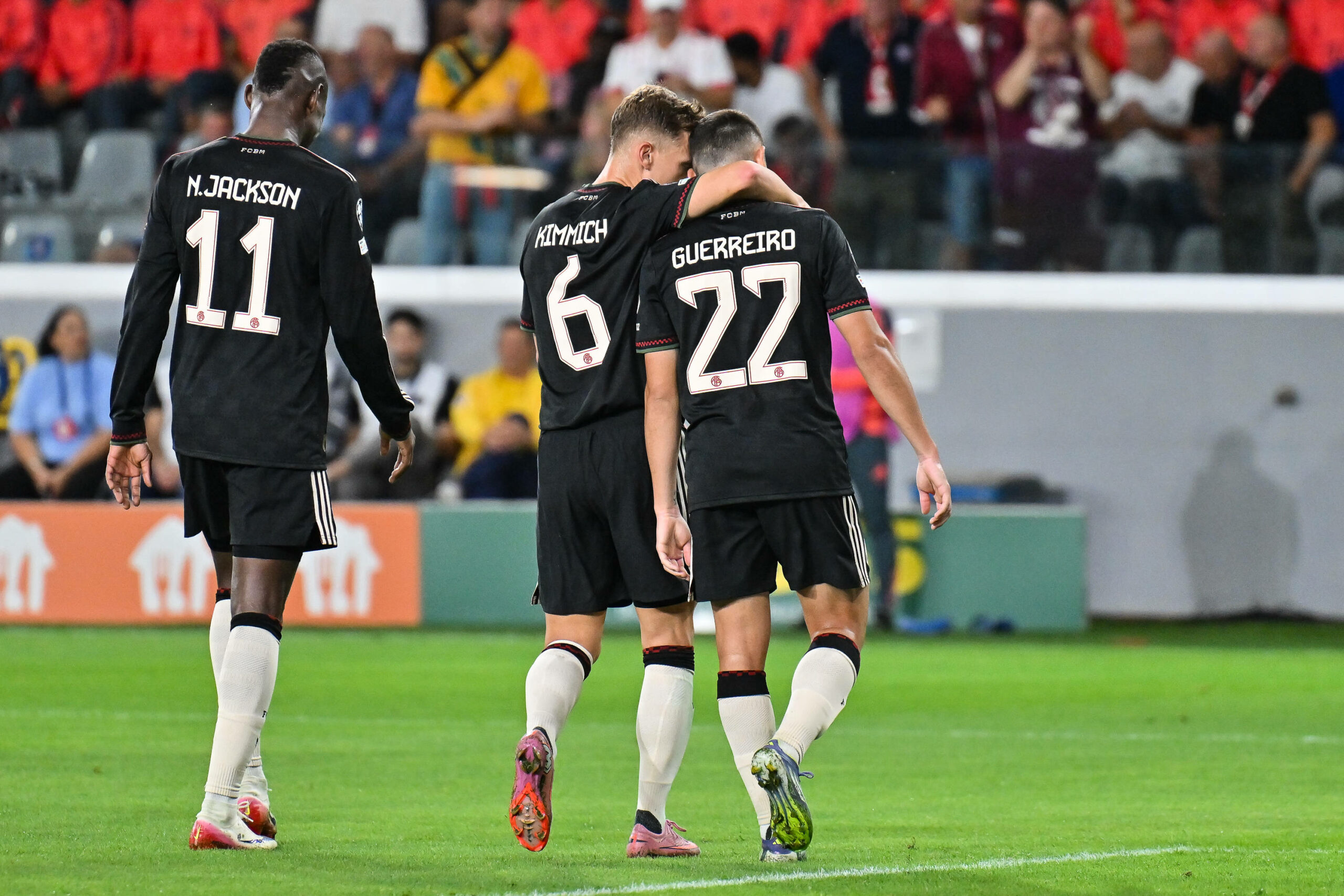 Joshua Kimmich mit Raphael Guerreiro im Arm, daneben Nicolas Jackson.