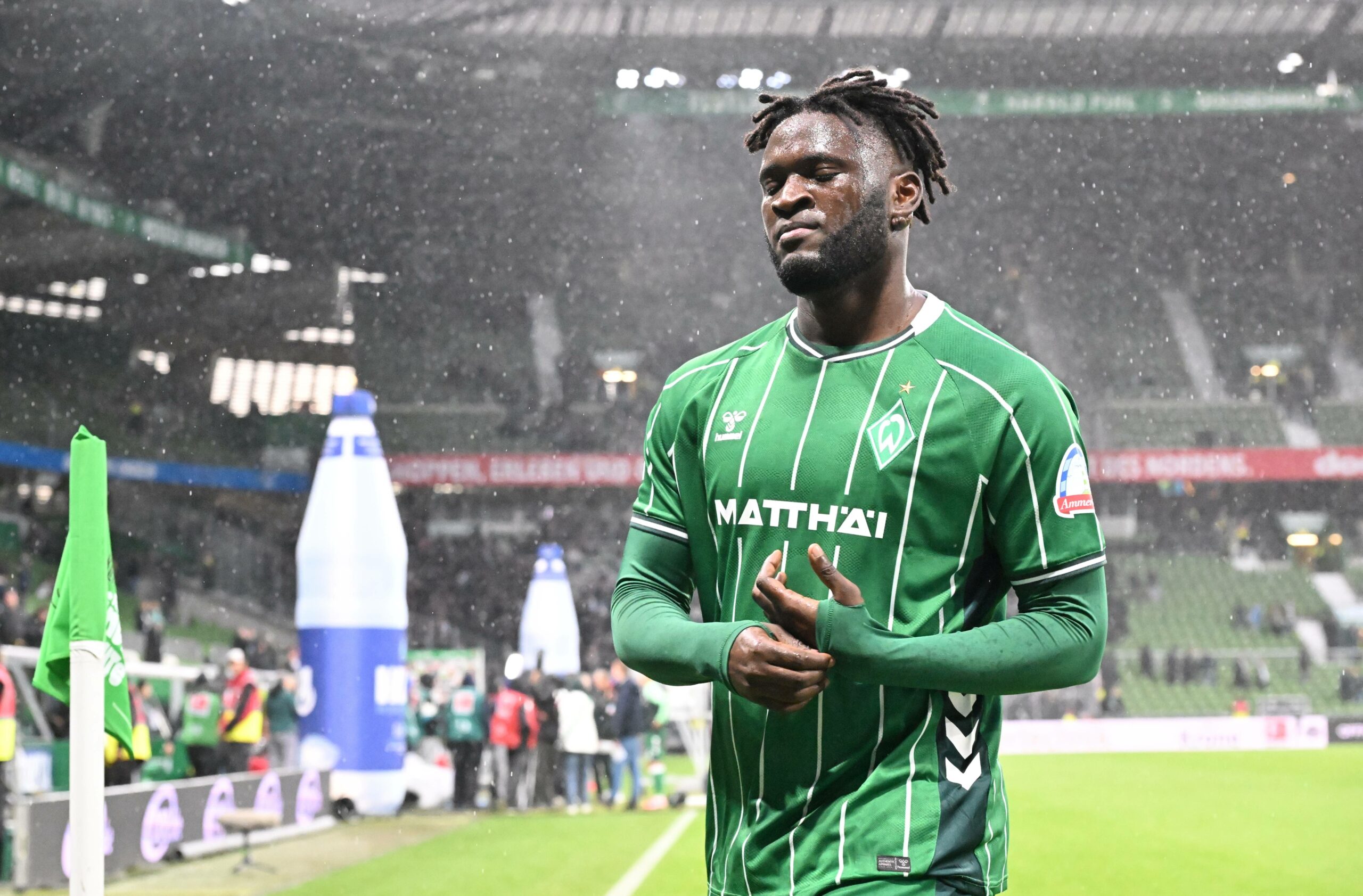 Stürmer Victor Boniface, im Trikot des SV Werder Bremen, im strömenden Regen auf dem Rasen des Weserstadions