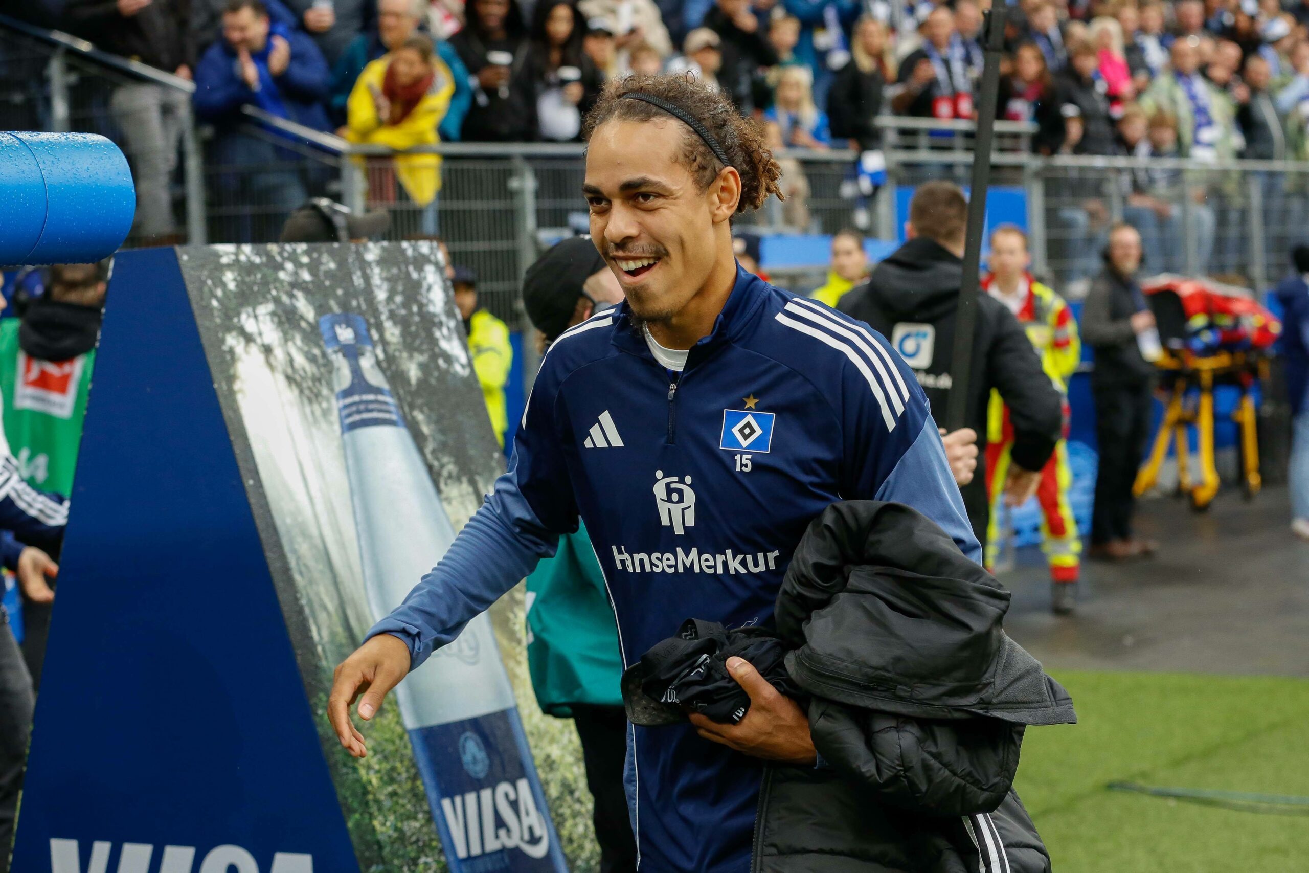 Yussuf Poulsen lächelt vor der HSV-Auswechselbank