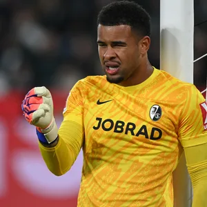 Noah Atubolu lehnt am Pfosten und dirigiert seine Mauer bei einem Freistoß.