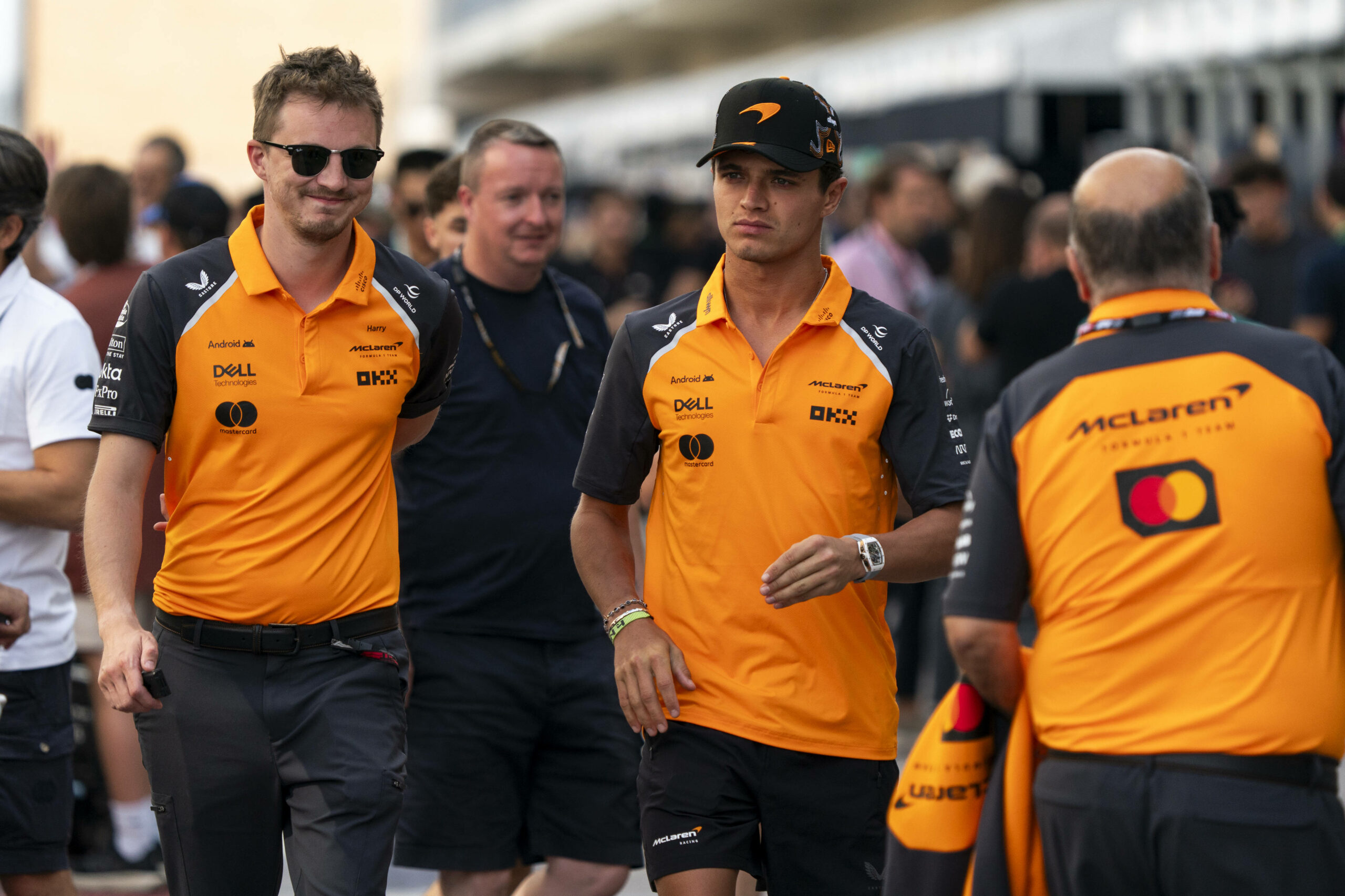 Lando Norris mit ernsster Miene, während er durch die Boxengasse geht.