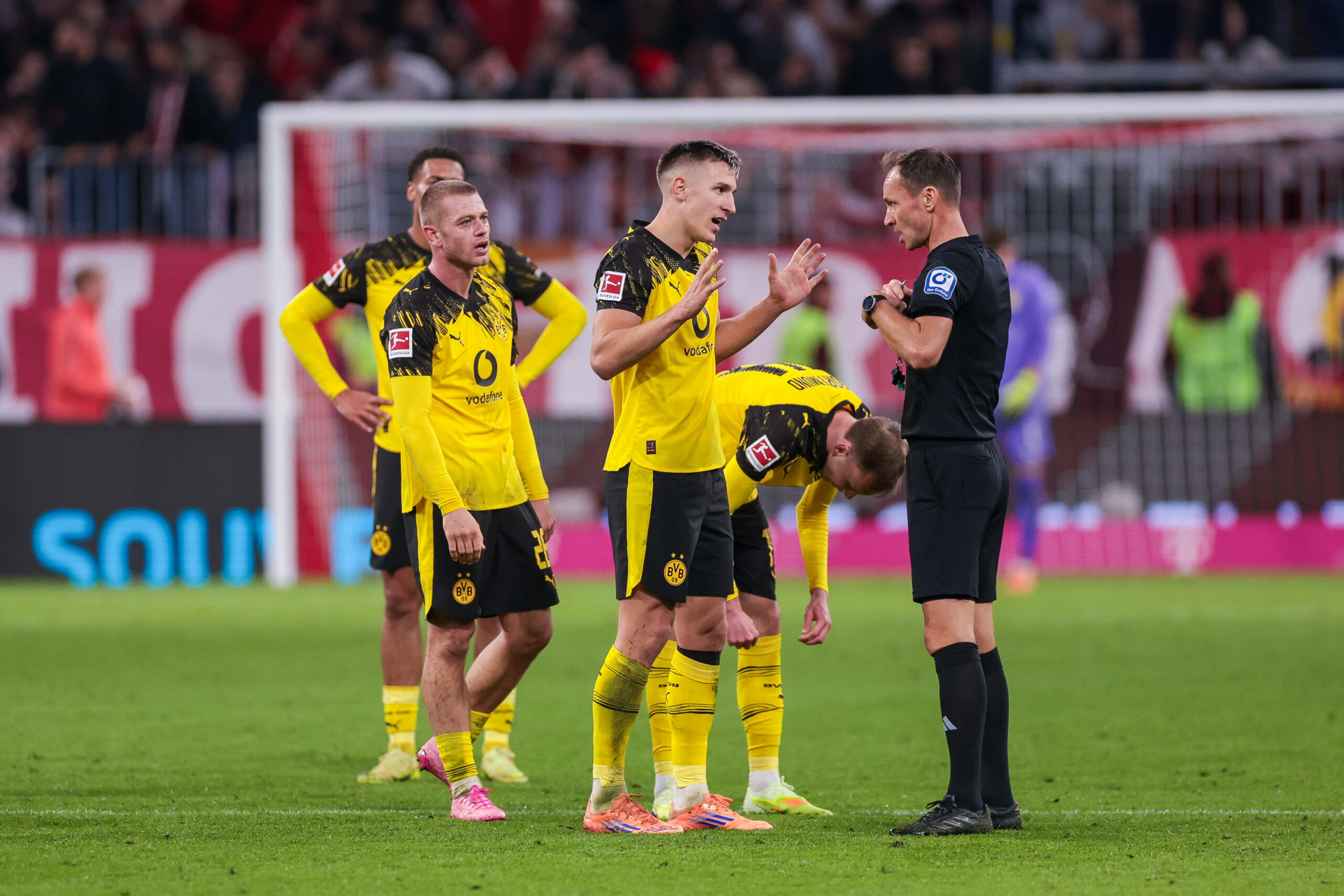 Dortmunder Spieler diskutieren mit Schiedsrichter Bastian Dankert