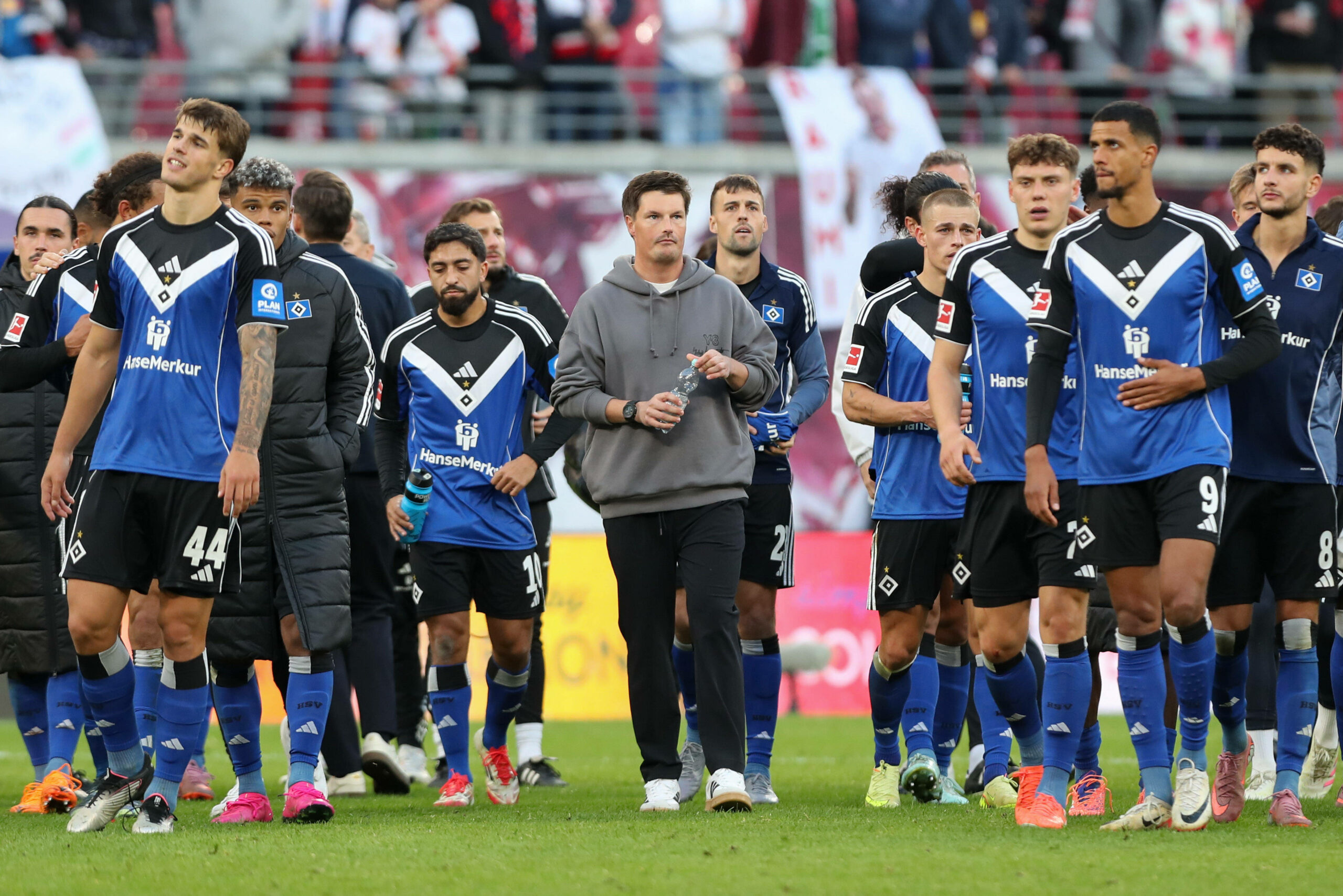 Merlin Polzin und die HSV-Profis gehen über das Spielfeld in Leipzig