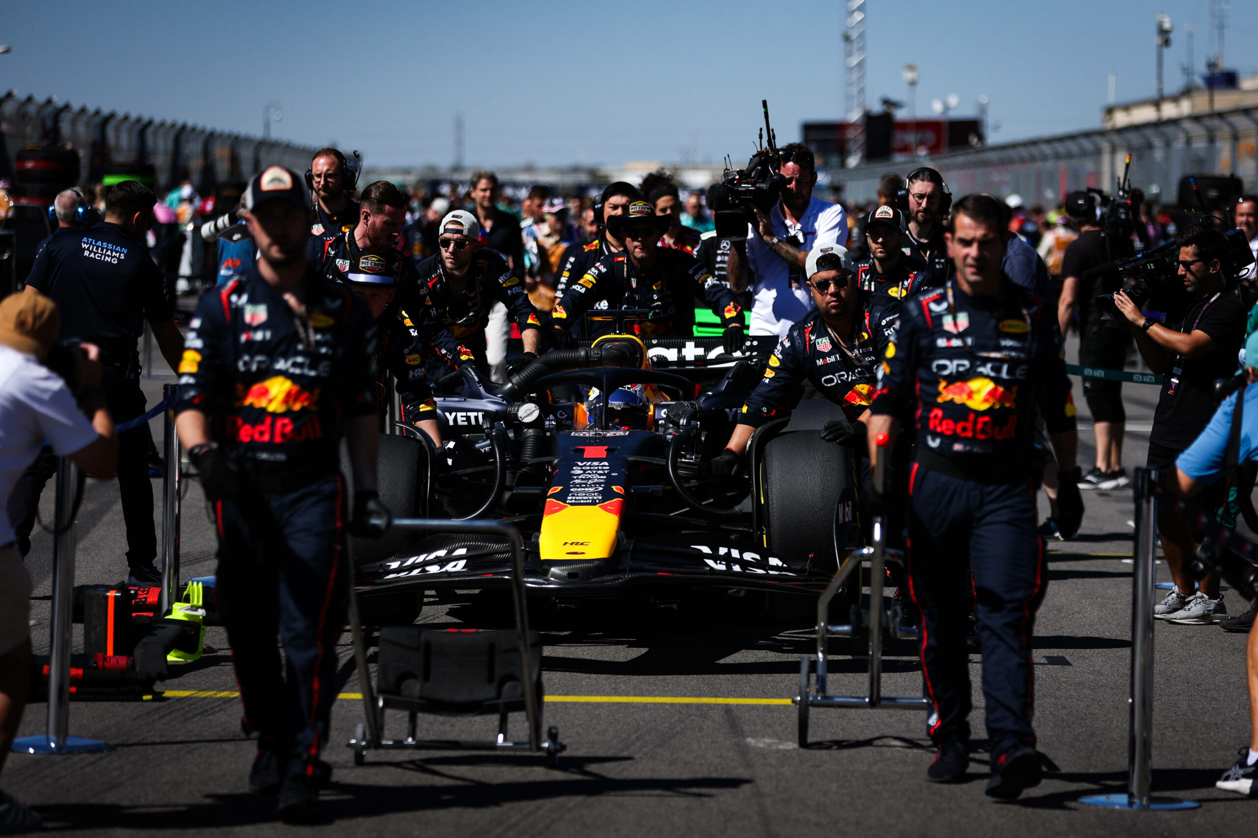 Red-Bull-Mechaniker schieben das Auto von Max Verstappen vor dem Rennstart zur Startposition