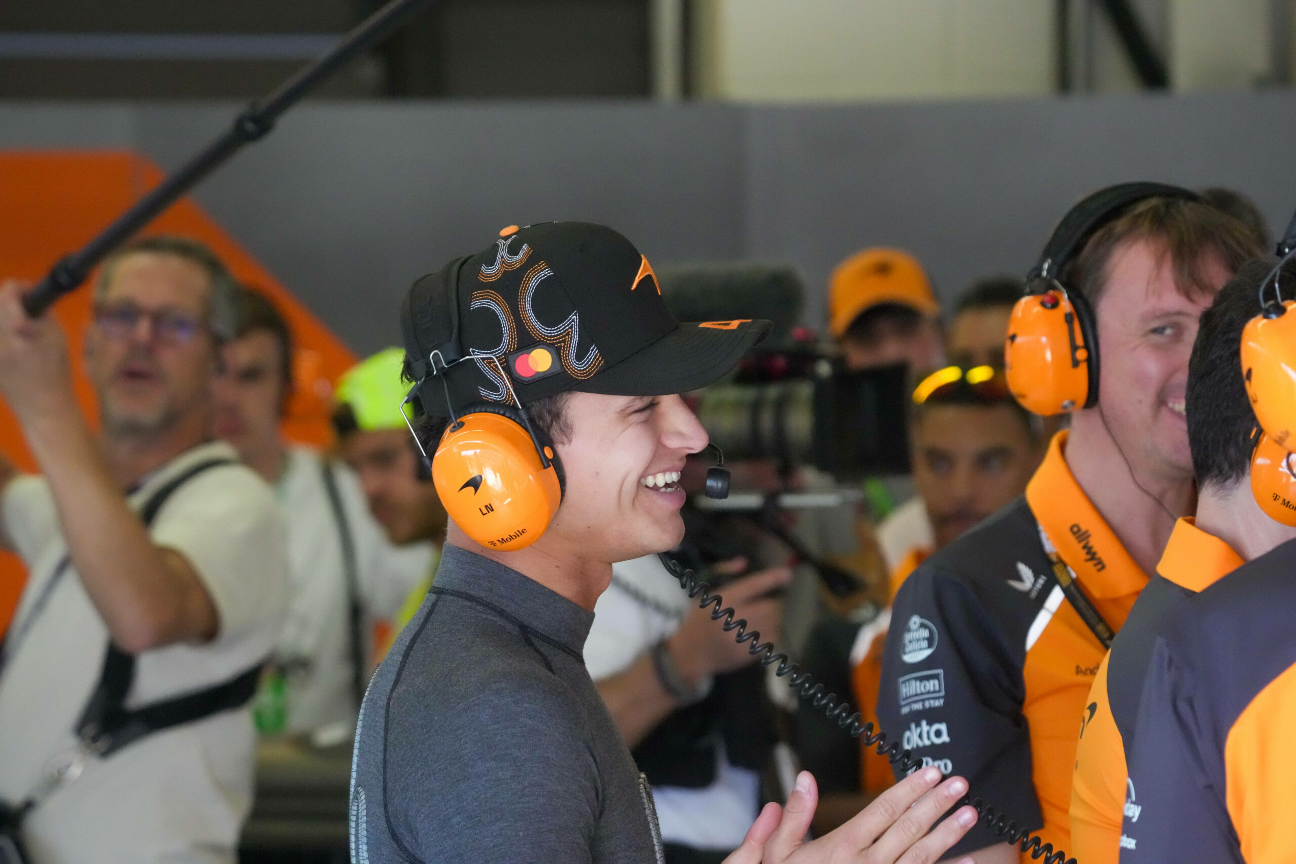 Lando Norris lachend in der Garage seines Teams McLaren Racing