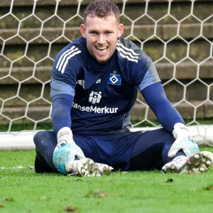 Daniel Peretz sitzt beim HSV-Training auf dem Rasen