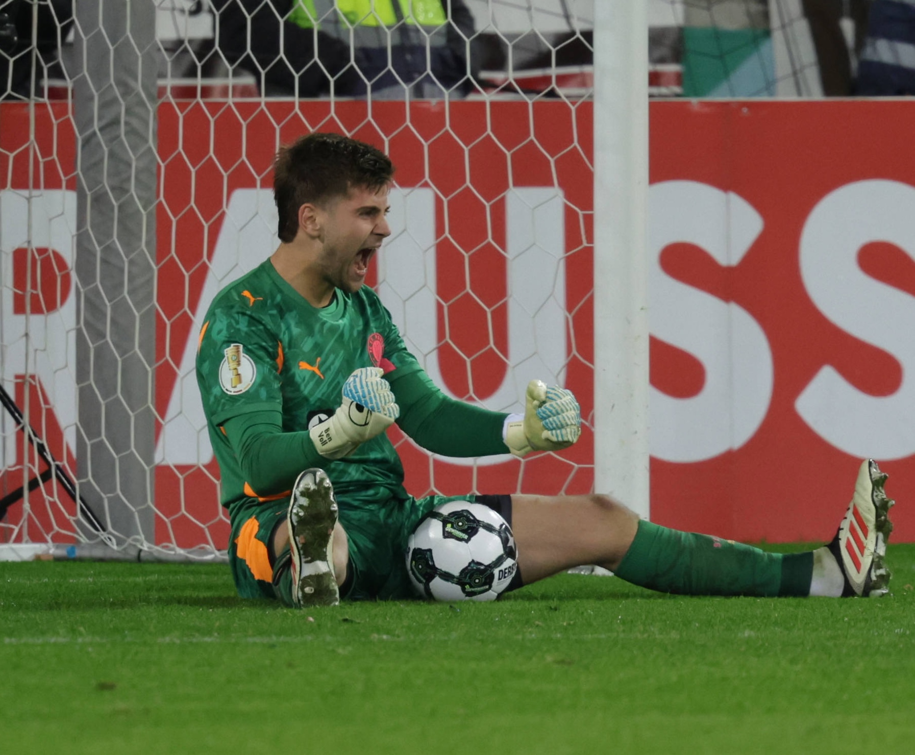 Ben Voll jubelt nach einem gehaltenen Elfer auf dem Boden sitzend