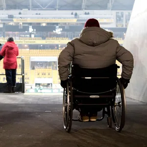 Fan mit Behinderung auf dem Weg zum Rollstuhlfahrerplatz im Stadion